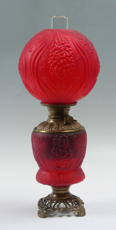 Appraisal: RED FLORAL SATIN GLASS OIL LAMP Embossed floral motif on