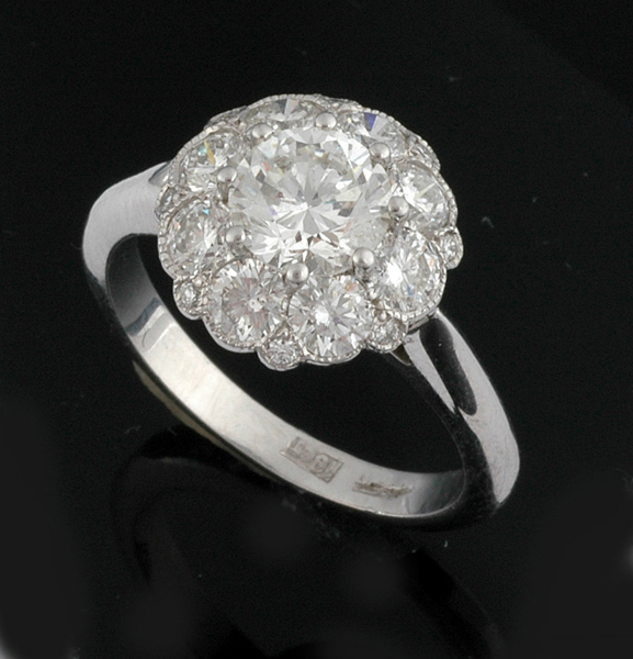 Appraisal: A DIAMOND CLUSTER RING The central claw set round brilliant