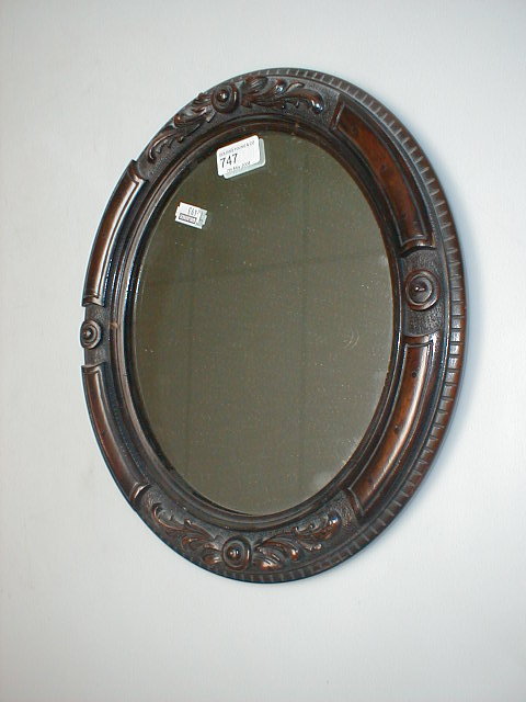 Appraisal: A late Victorian carved walnut oval wall mirror high