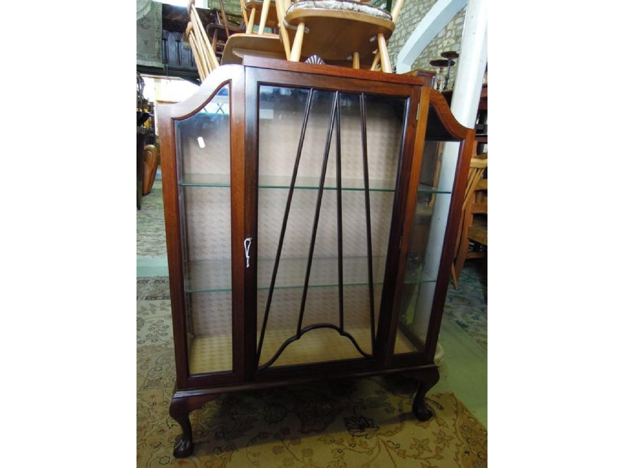 Appraisal: An Edwardian mahogany display cabinet with shaped outline enclosed by