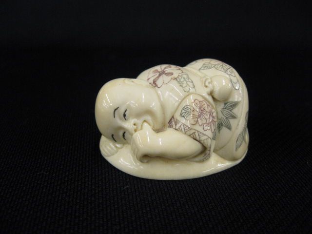 Appraisal: Small Ivory Figurine of a Young Child reclining sucking his