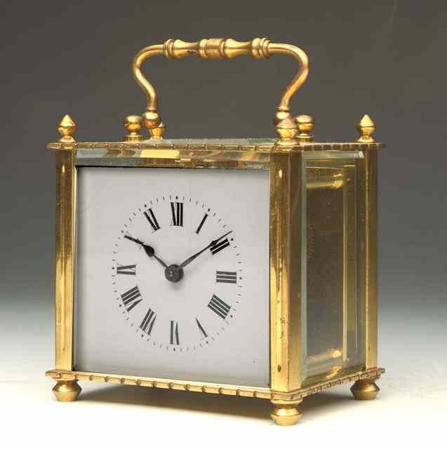 Appraisal: A BRASS CARRIAGE TIMEPIECE with white enamel Roman dial and