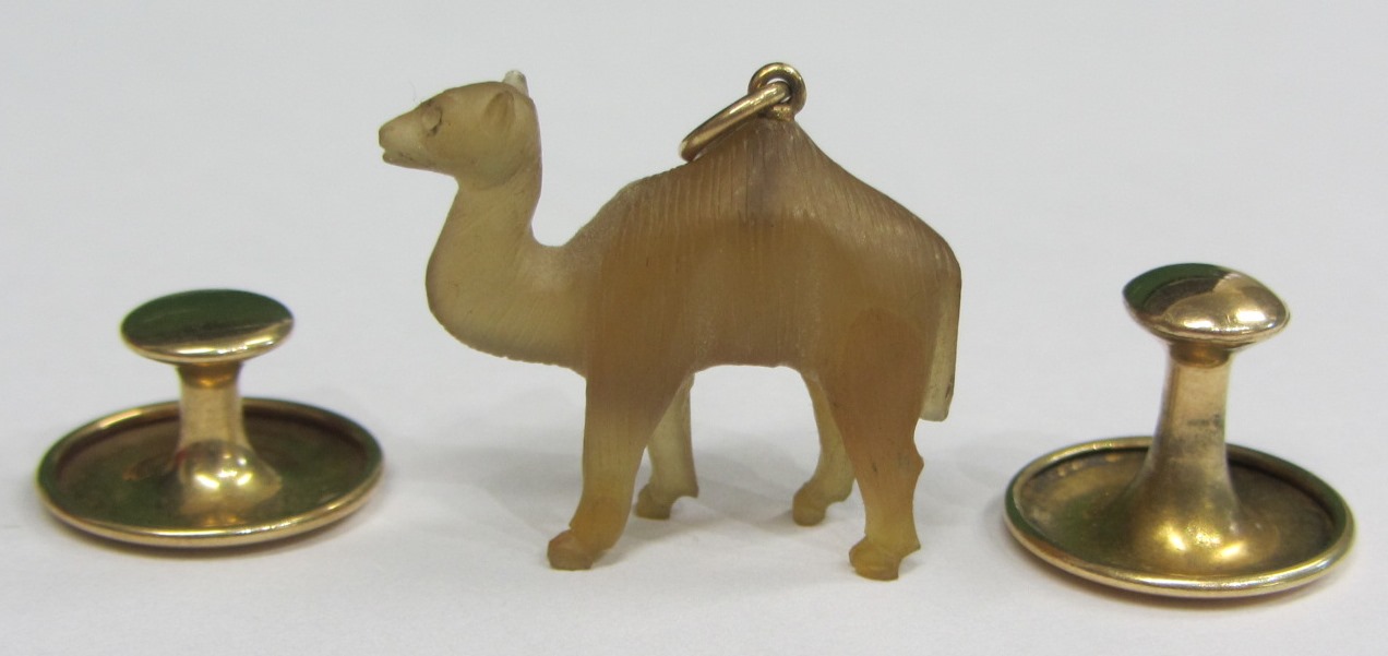 Appraisal: A carved pale brown chalcedony pendant designed as standing camel