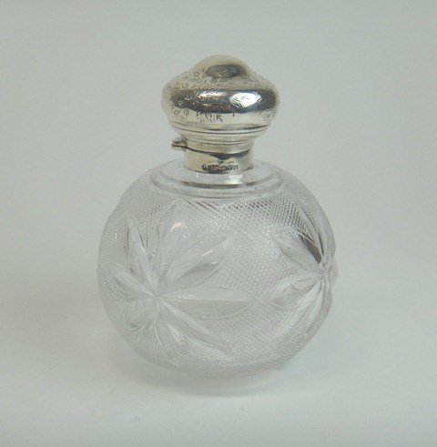 Appraisal: A silver topped faceted spherical glass scent bottle the hinged