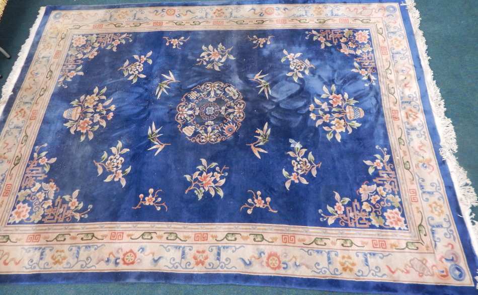 Appraisal: A Chinese blue wool cut rug decorated with flowers etc