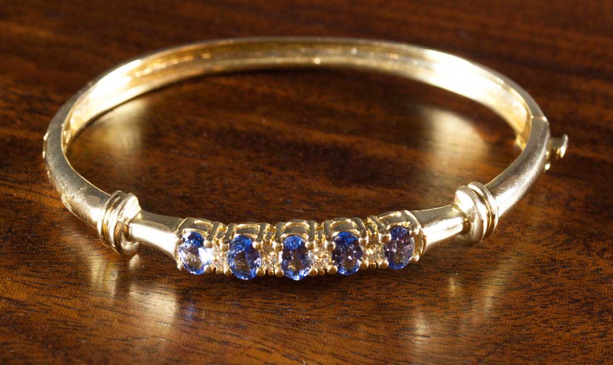 Appraisal: TANZANITE DIAMOND AND FOURTEEN KARAT GOLD BANGLE The yellow gold