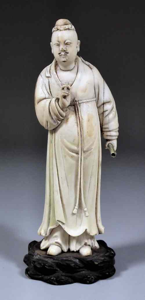 Appraisal: A Chinese carved ivory figure of a scholar holding a