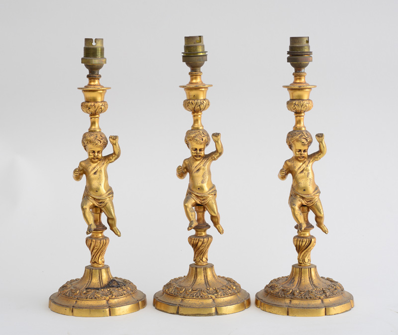 Appraisal: THREE NAPOLEON III STYLE GILT-METAL FIGURAL CANDLESTICKS MOUNTED AS LAMPS