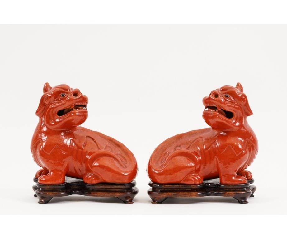 Appraisal: Pair of Chinese red porcelain seated foo dogs on wood