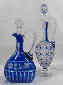 Appraisal: Two blue overlay cut glass claret jugs one oval with