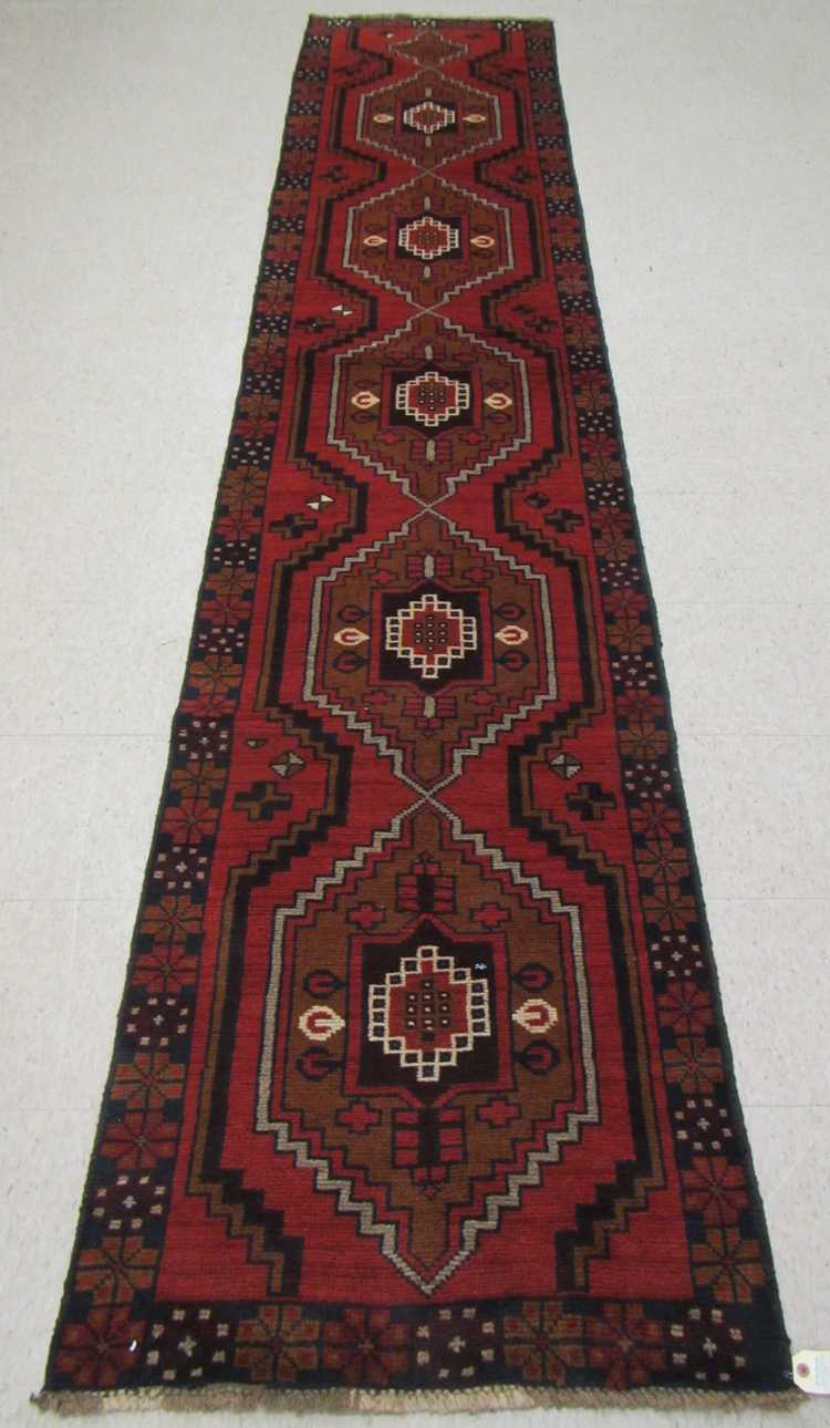 Appraisal: HAND KNOTTED ORIENTAL RUNNER Pakistani Belouch five geometric medallions on