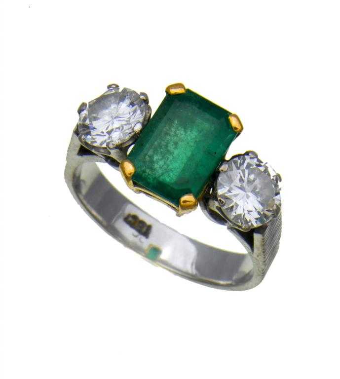 Appraisal: AN EMERALD AND DIAMOND RING the step cut emerald flanked