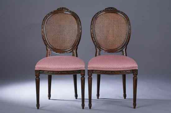 Appraisal: PAIR LOUIS XVI STYLE WALNUT SIDE CHAIRS Carved ribbon-banded crest