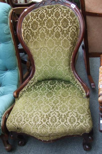 Appraisal: A Victorian mahogany nursing chair with carved crest over serpentine