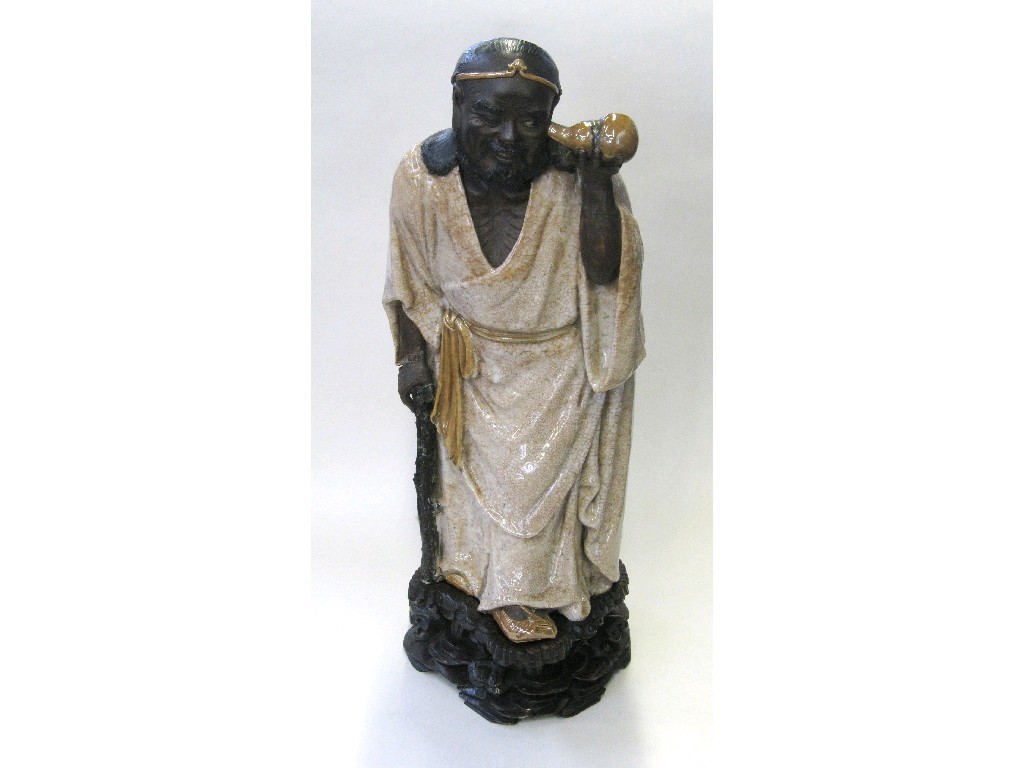 Appraisal: Oriental figure of a Sage modelled looking into a gourd