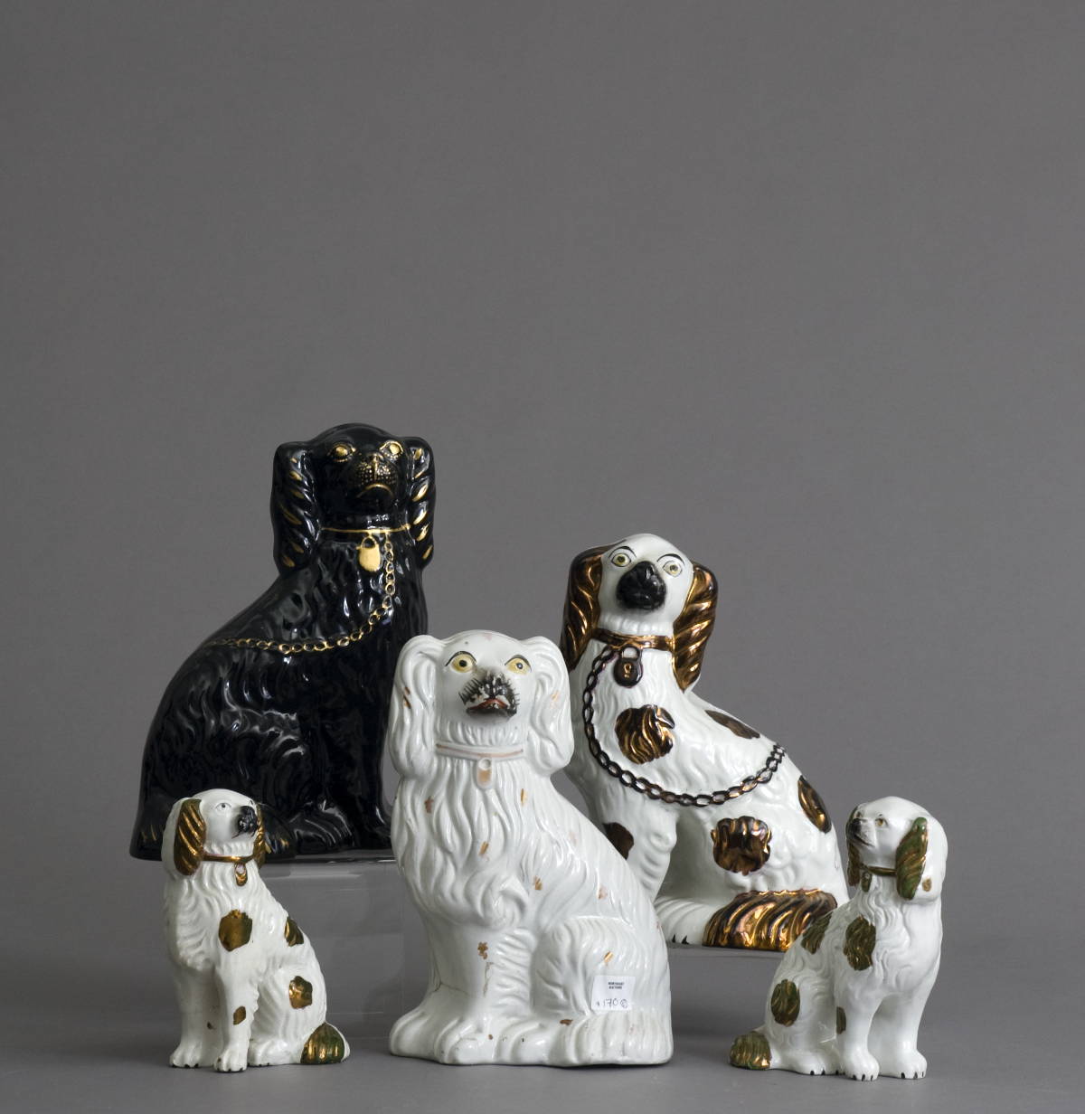 Appraisal: FIVE STAFFORDSHIRE FIGURES OF DOGS INCLUDING THREE WITH COPPER LUSTRE