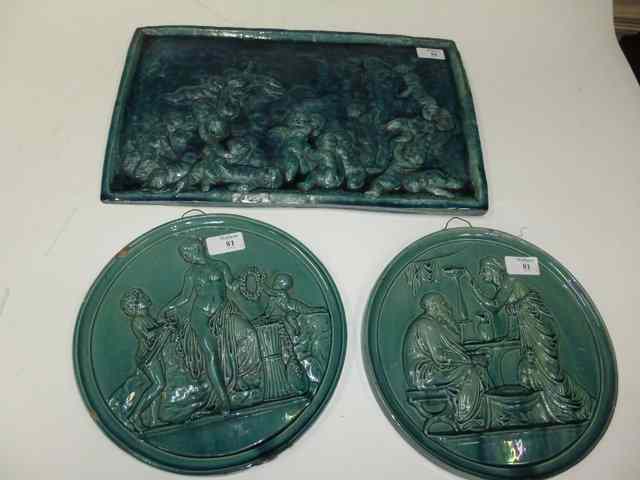 Appraisal: A BLUE GLAZED POTTERY PLAQUE decorated in relief with putti