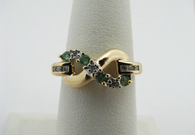 Appraisal: K yellow gold ring figure design with emerald and three