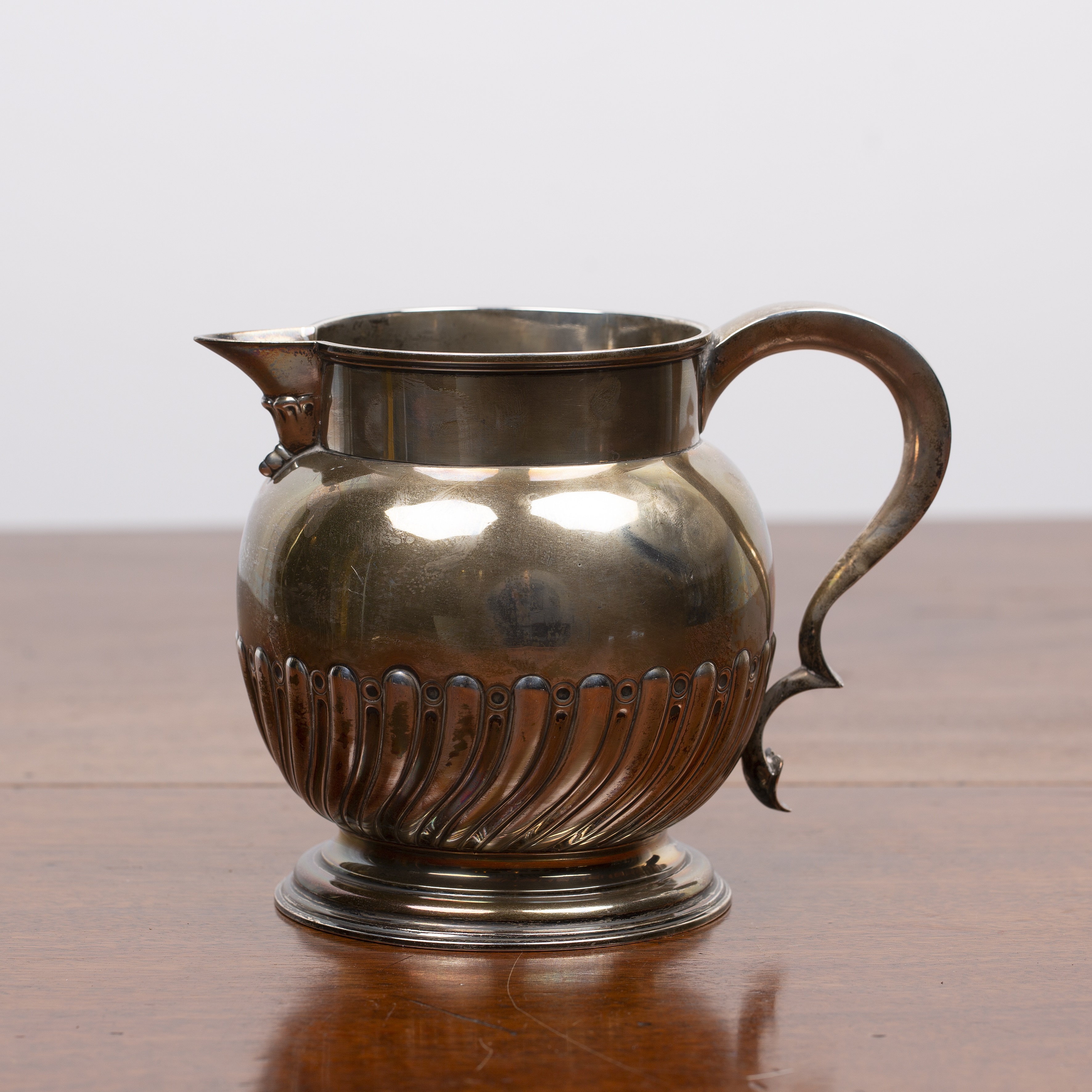 Appraisal: Victorian silver jug with trophy handle on circular base bearing