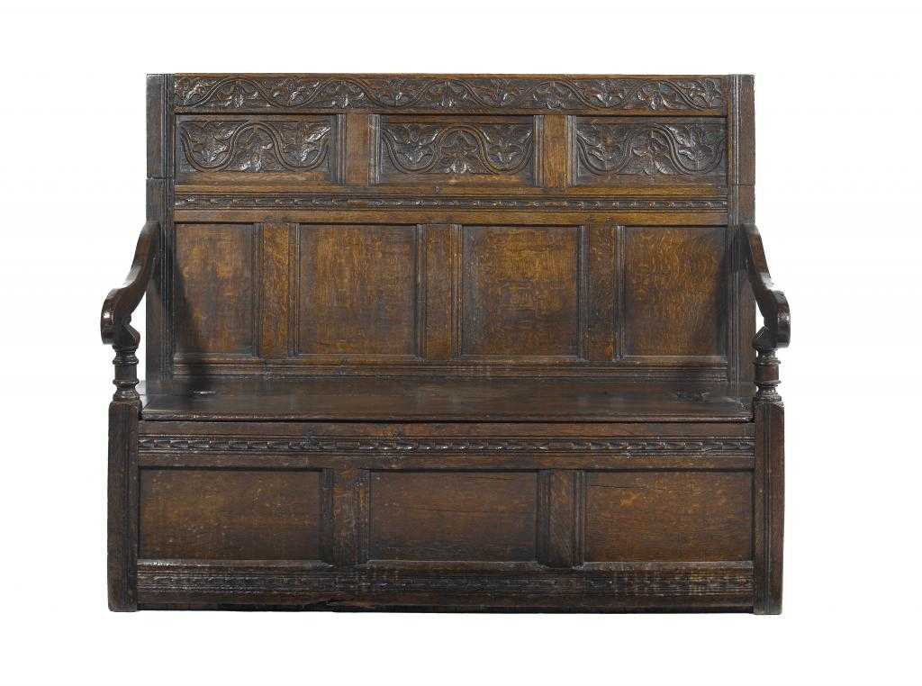 Appraisal: AN OAK SETTLE of panelled construction the back carved with