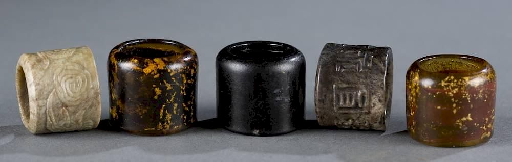 Appraisal: Group of glass and jade thumb rings A group of