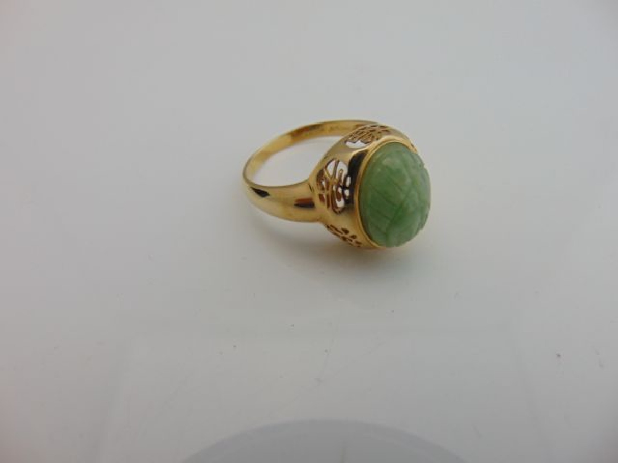 Appraisal: A Chinese ring centred with an oval carved jade motif