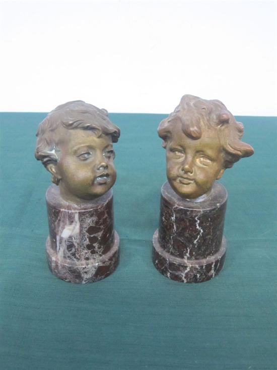 Appraisal: PAIR ANTIQUE BRONZE HEADS OF PUTTI On rouge marble pedestals