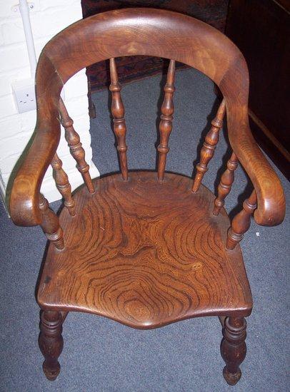 Appraisal: A th Century spindle chair with solid seat in elm