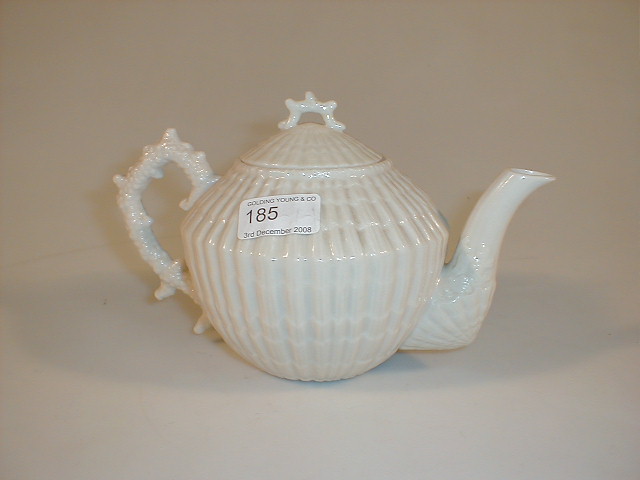 Appraisal: A Belleek ivory glaze shell moulded teapot with a coral