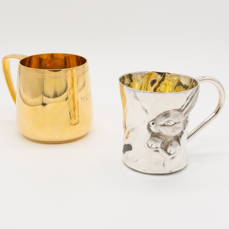 Appraisal: TWO SILVER CHILD'S MUGS Comprising A cup molded with a