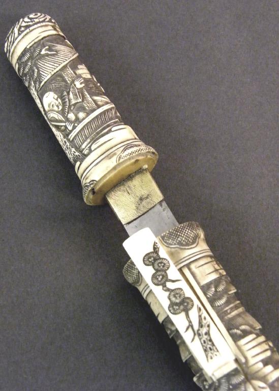 Appraisal: Japanese carved bone dagger and scabbard stained and decorated in