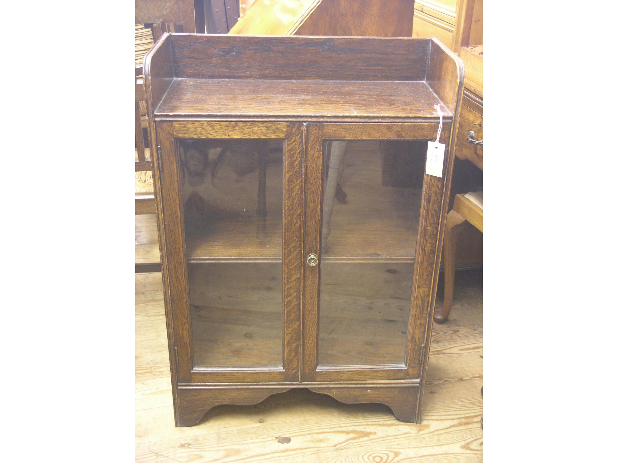 Appraisal: A solid dark oak dwarf bookcase single shelf enclosed by