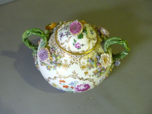 Appraisal: A German porcelain spherical shaped flower encrusted pot and cover