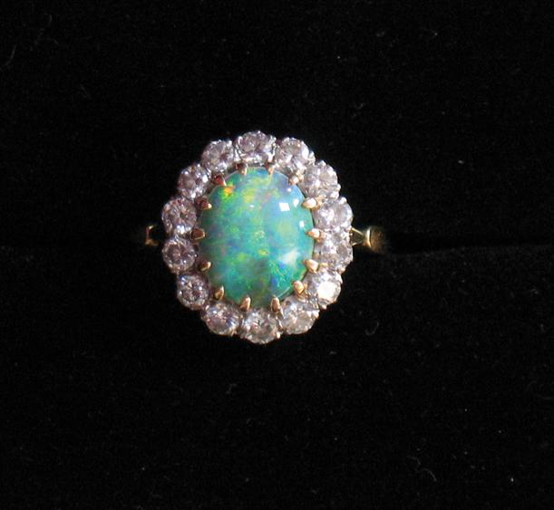 Appraisal: A DIAMOND AND OPAL CLUSTER RING the central oval black