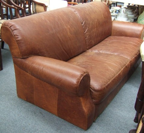 Appraisal: A th century leather sofa with roll over back and