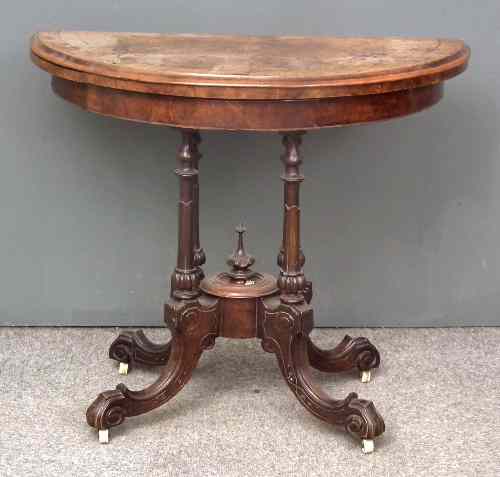 Appraisal: A Victorian walnut semi-circular card table inlaid with leaf scroll