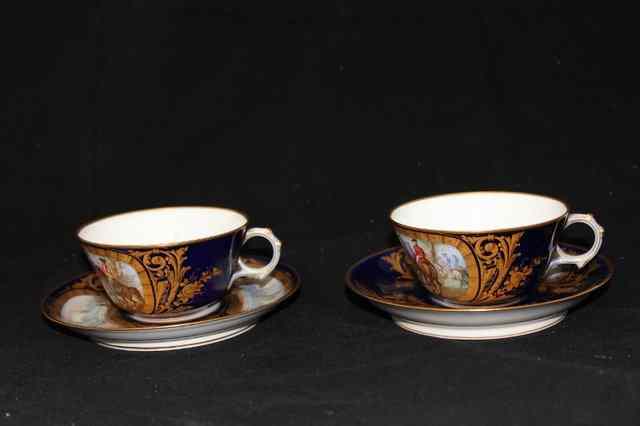 Appraisal: A PAIR OF SEVRES PORCELAIN BLUE GROUP CUPS AND SAUCERS