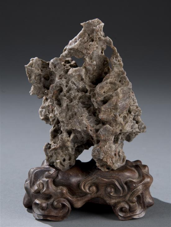 Appraisal: Chinese scholars rock with carved rosewood stand Rock having the