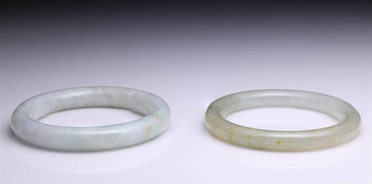 Appraisal: Two Chinese carved jadeite bangles one with some rust coloration