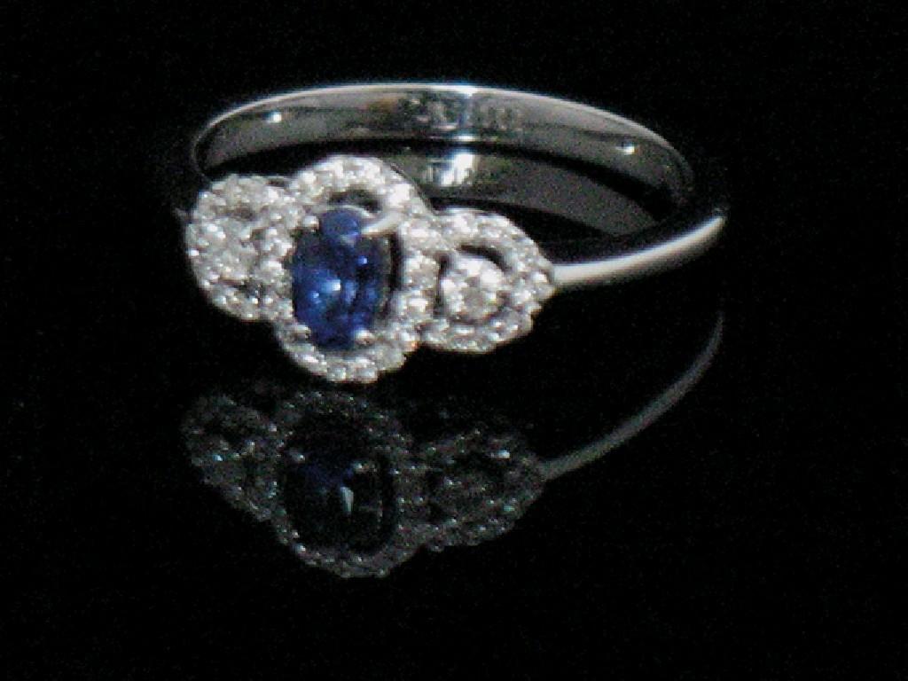 Appraisal: A SAPPHIRE AND DIAMOND DRESS RING the central oval-cut sapphire