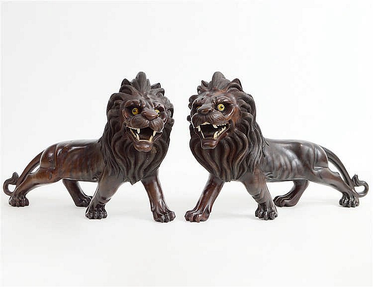 Appraisal: PAIR OF CARVED HARDWOOD MALE LIONSProbably Southeast Asia Each with