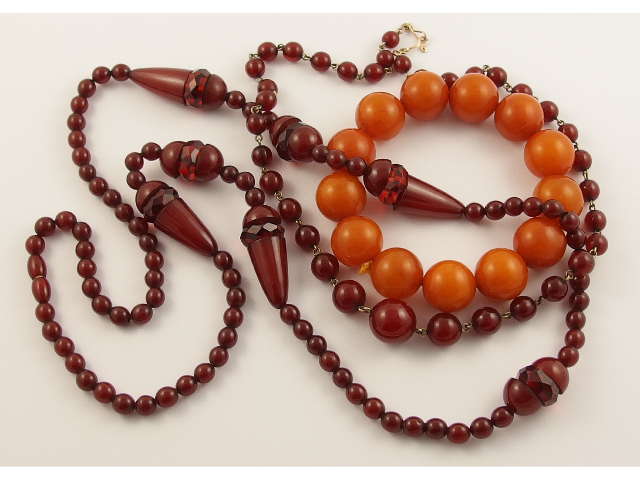 Appraisal: An orange amber colour bead braceletthe thirteen round beads are