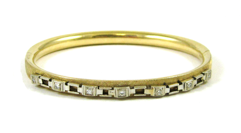 Appraisal: DIAMOND AND FOURTEEN KARAT GOLD BANGLE The oval hinged yellow