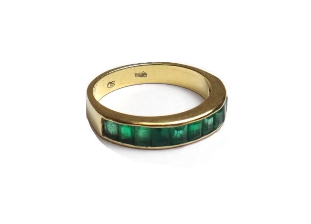 Appraisal: A gold and emerald set half hoop eternity ring mounted