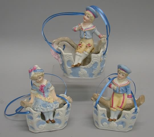 Appraisal: Bisque Swing figurines children in baskets Group of unmarked children