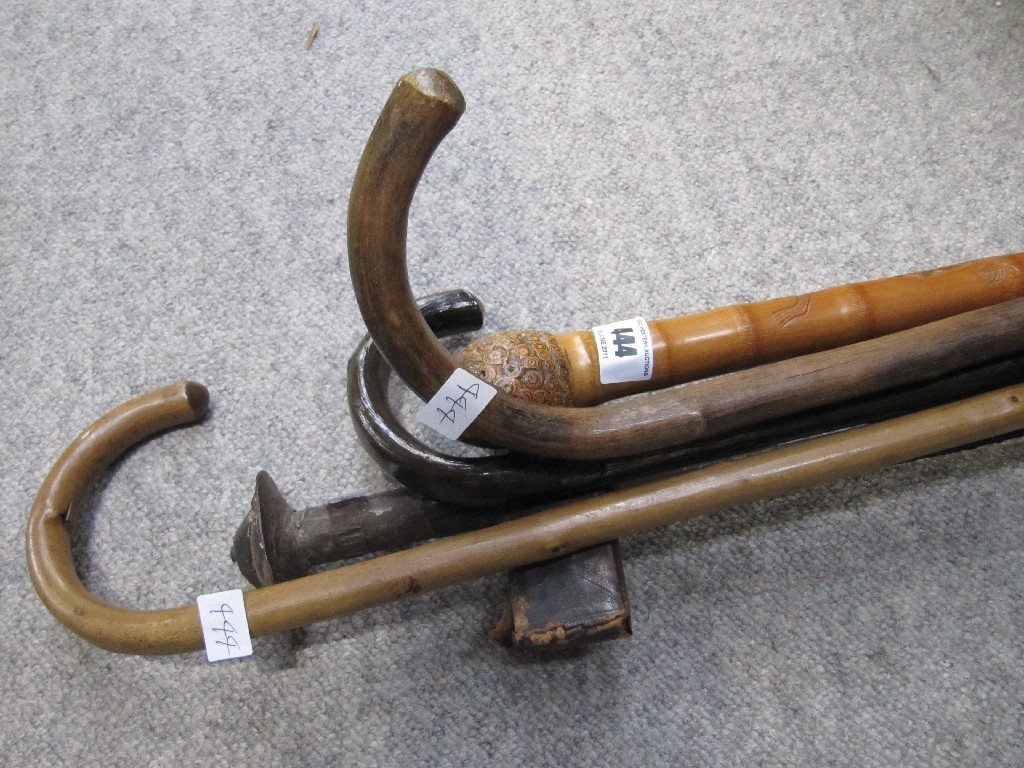 Appraisal: Lot comprising four walking sticks and a sword