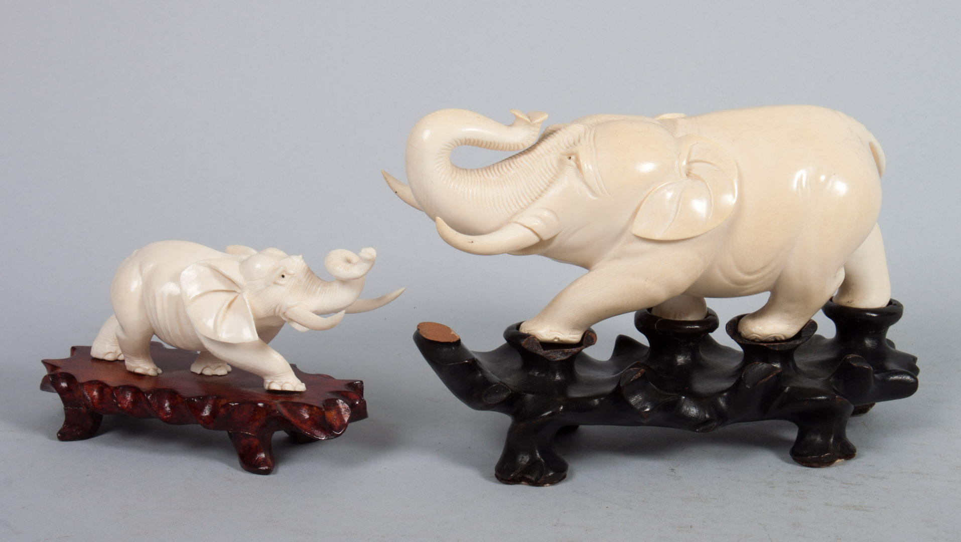 Appraisal: Two African carved ivory elephants large and small charging elephants