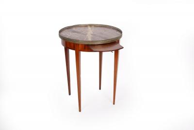 Appraisal: A French marble top mahogany table with brass gallery surround