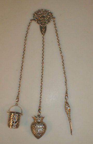 Appraisal: A Victorian silver chatelaine with three trains containing a bucket