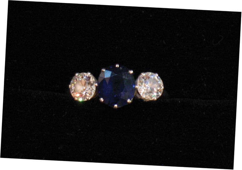 Appraisal: A THREE STONE SAPPHIRE AND DIAMOND RING the central cushion-cut